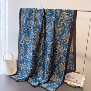 Écharpe en soie bleu marine avec motif floral baroque doré sur un support en métal