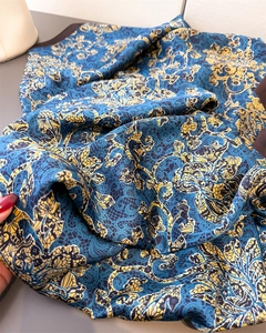 Gros plan détaillé d'un foulard en soie imprimé paisley baroque aux motifs bleus et jaunes