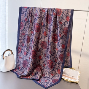 Vue détaillée d'un foulard en soie bleu marine avec motifs traditionnels chinois rouges