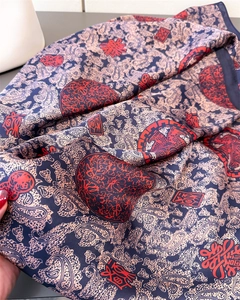 Détail d'une écharpe en soie bleu marine avec motifs paisley et caractères Fu rouges