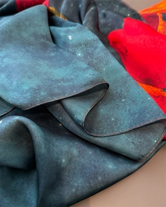 Macro shot of faux silk scarf showing deep blue rose print and smooth satin texture