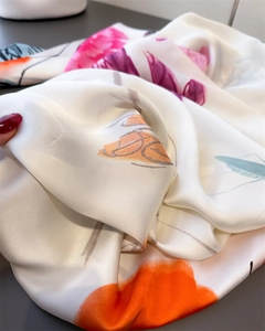 Close-up of silk-like satin shawl showing vibrant rose floral print and smooth fabric texture