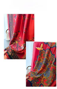 Détail d'un foulard en soie rouge montrant des motifs de papillons et de fleurs fluides