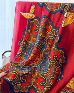 Détail du tissu soyeux rouge avec imprimé de papillons et motifs mandala élégants