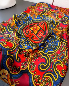 Gros plan d'une écharpe en satin de soie montrant des motifs ethniques et texture lisse