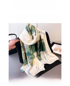 Détail d'une écharpe en soie avec imprimé lotus vert sur une veste de costume noire