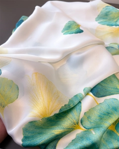 Vue macro détaillée du tissu en soie montrant la texture lisse et l'imprimé ginkgo