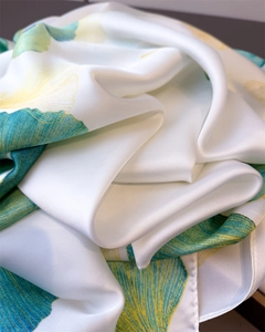 Détail du foulard en soie blanche avec motifs de feuilles de ginkgo et texture satinée
