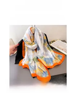 Detailed texture of thin silk scarf with blue chrysanthemum print and orange borders