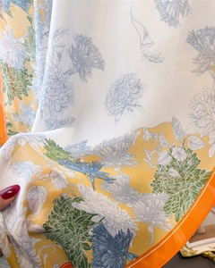 Detail of soft silk-like fabric showing vibrant floral prints and smooth texture