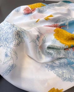 Close-up of lightweight floral silk scarf with elegant yellow and blue chrysanthemum prints