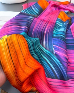 Detailed view of glossy satin scarf with vibrant colorful dynamic stripe print and texture