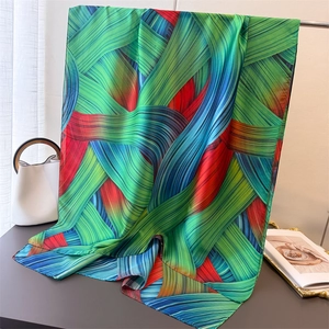 Vibrant abstract print silk scarf with dynamic woven lines in green and orange tones