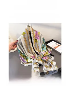Detail of silk scarf with pink floral peony patterns and golden chain border accents