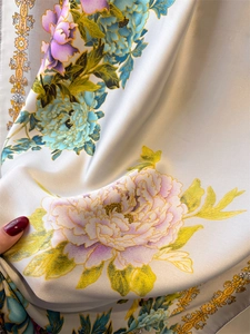 Detailed macro view of floral silk scarf with golden scrolls and purple peonies