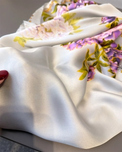 Detailed macro shot of floral silk scarf with elegant purple peony prints and pearly sheen