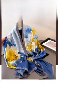 Detail of silk-like floral scarf with blue and yellow watercolor patterns and grey edges