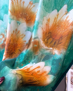 Close-up of elegant water lily print on soft silk scarf with premium draped texture