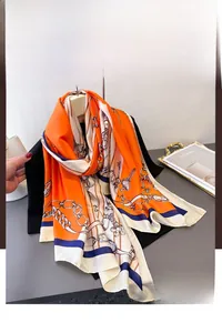 Detail of elegant orange and beige silk scarf with classic chain and floral print
