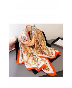 Detail view of floral print silk scarf with vibrant orange border and abstract flower patterns