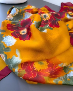 Close-up of golden silk scarf with elegant red peony and white chrysanthemum floral prints