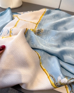 Detailed macro of silk scarf showing floral patterns and smooth satin fabric texture