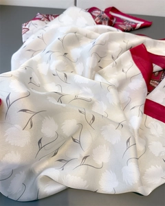 Detailed texture of ivory silk scarf featuring white flowers and burgundy borders