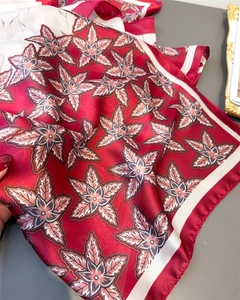 Detail of deep red floral satin scarf featuring an elegant star pattern and smooth texture