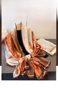 Detail of printed silk scarf with artistic leaf patterns and smooth glossy texture