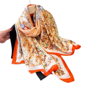 Floral print satin scarf in orange and beige with bright border drape view