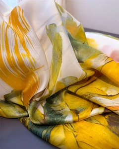Close-up of abstract floral silk scarf fabric showing smooth satin texture and fine stitching