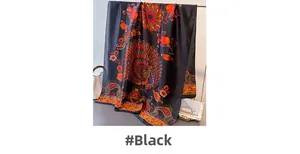 Detail eines eleganten schwarzen Seidenschals mit Pfauen- und Paisley-Blumenmuster