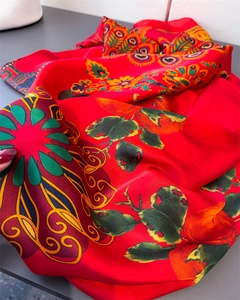 Detail eines roten Pfau-Seidenschals mit Mandala-Mustern und glatter Satin-Textur