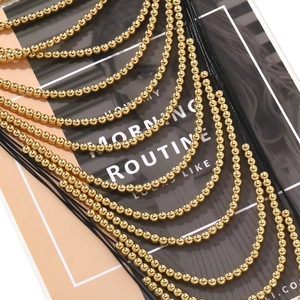 Macro view of multi-layered golden beaded necklace with intricate woven strands