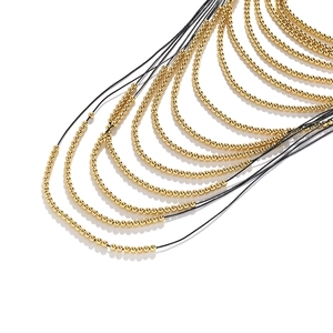 Multi-strand waterfall necklace with polished gold beads and black woven cords