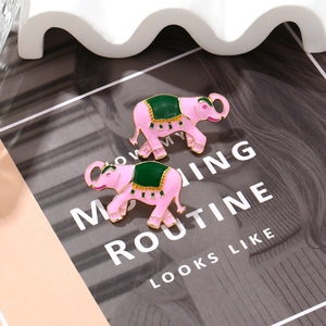 Boucles d'oreilles éléphant en émail rose chic avec selle verte et glands dorés