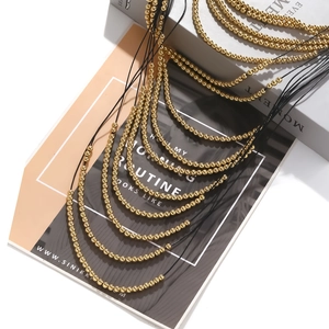 Exaggerated layered gold beaded necklace with black cord multi-strand waterfall design