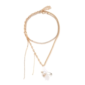 Collier multicouche doré avec perle baroque et pendentif épingle sur fond blanc