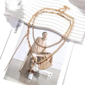Détail du collier multi-rangs doré avec strass et pendentif en perle en forme de cœur