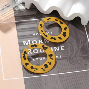 Boucles d'oreilles créoles émaillées en C avec motif léopard jaune sur support ondulé