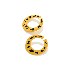 Détail de créoles en alliage en forme de C avec émail jaune et motif léopard noir