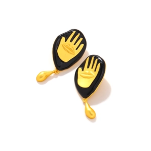 Detail of retro black enamel earrings with golden palm lip relief and teardrop pendant