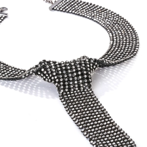 Macro detail of rhinestones on black mesh metal tie necklace with adjustable chain