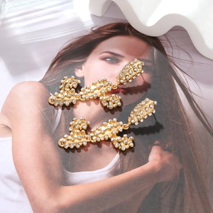 Detail of gold-plated long cactus earrings with pave-set white rhinestones and link structure