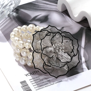 Bohemian multi-layer pearl bracelet with a large silver floral charm and rhinestones