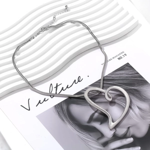 Detailed view of silver snake chain necklace featuring a large hollow heart pendant