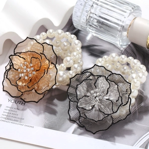 Close-up of handmade beaded floral bracelet with hollow metal petals and pearls