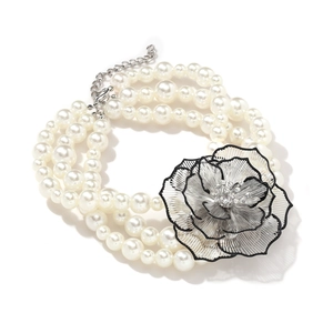 Détail d'un collier de perles multicouche avec pendentif fleur 3D noir et blanc