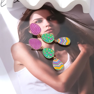 Dettaglio di orecchini pendenti a tre livelli con uova di Pasqua colorate in smalto