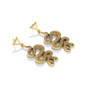 Détail de boucles d'oreilles serpent dorées avec écailles texturées et clous triangulaires blancs